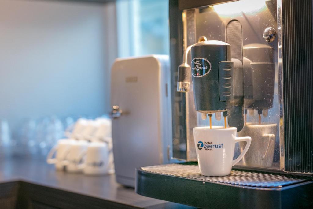 eine Kaffeemaschine auf einer Theke mit einer Tasse in der Unterkunft Hotel Zeerust Texel in De Koog