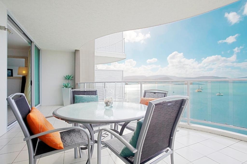 a dining room with a table and chairs on a balcony at at Marina Shores in Airlie Beach