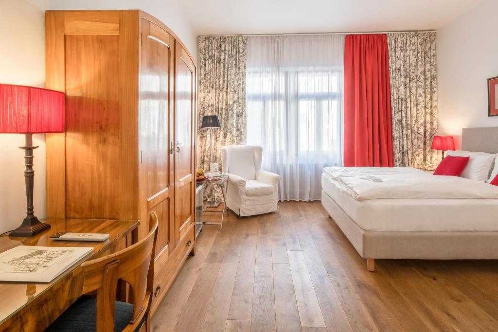 a hotel room with a bed and a table and a desk at Hotel Deutscher Kaiser in Nürnberg