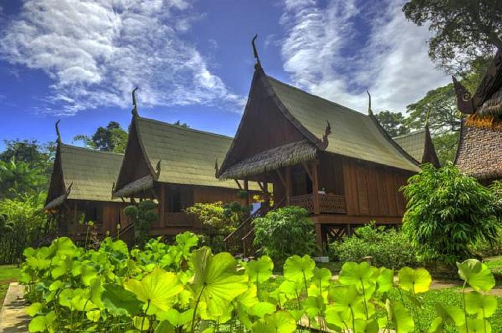 a building with a roof with green plants in front of it at Lanna Ban Hotel in Puerto Viejo