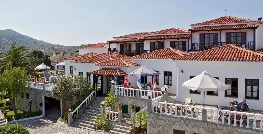 een uitzicht op een gebouw met tafels en parasols bij Dionyssos in Skopelos Town