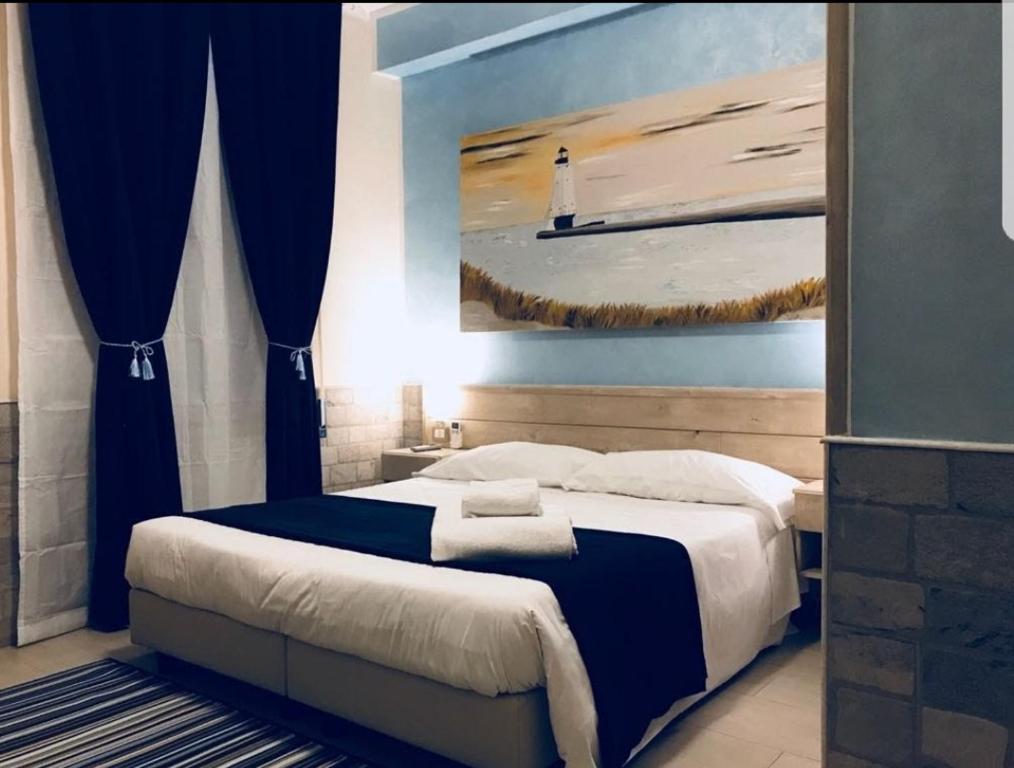 um quarto com uma cama com uma pintura de um farol em Fiumicino Airport B&B Deluxe em Fiumicino