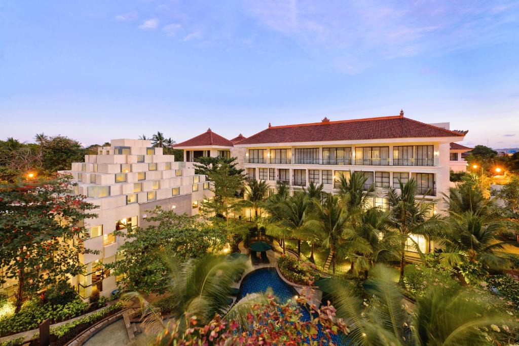 a building with a pool in front of a resort at Bali Nusa Dua Hotel in Nusa Dua