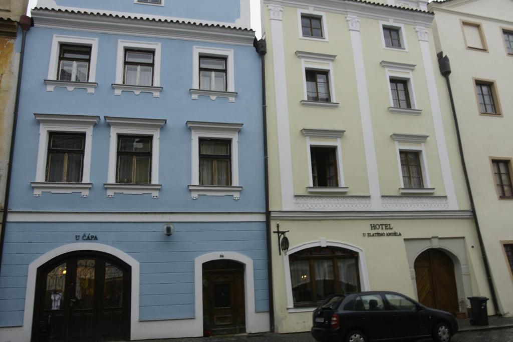 a blue building next to two white buildings at Hotel U Zlateho Andela in Pardubice