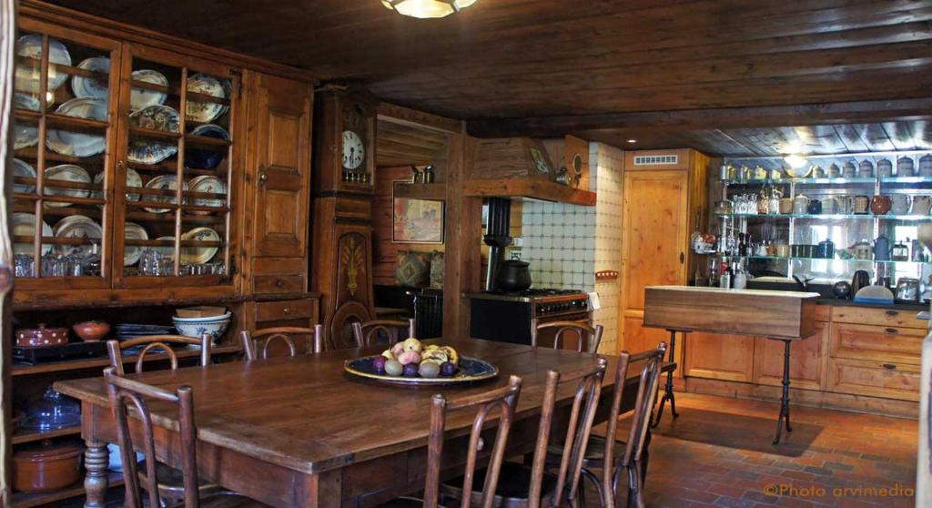 uma sala de jantar com uma mesa de madeira e cadeiras em Chalet le 1791 em La Clusaz