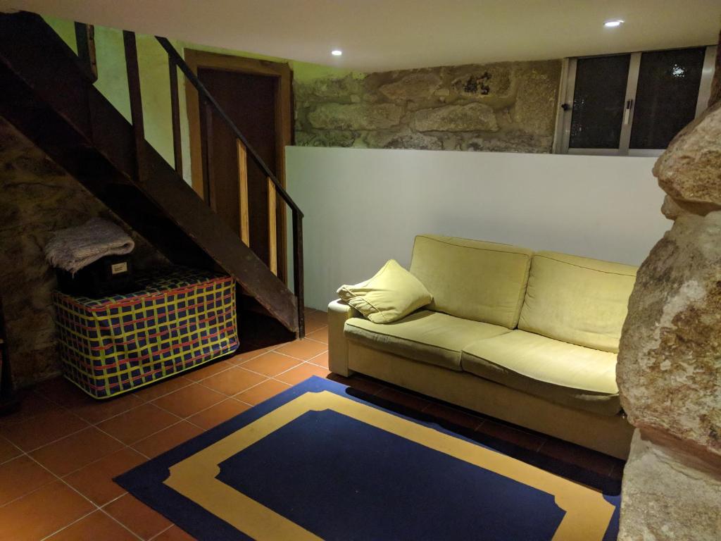 a living room with a couch and a staircase at Guesthouse Monsanto in Porto