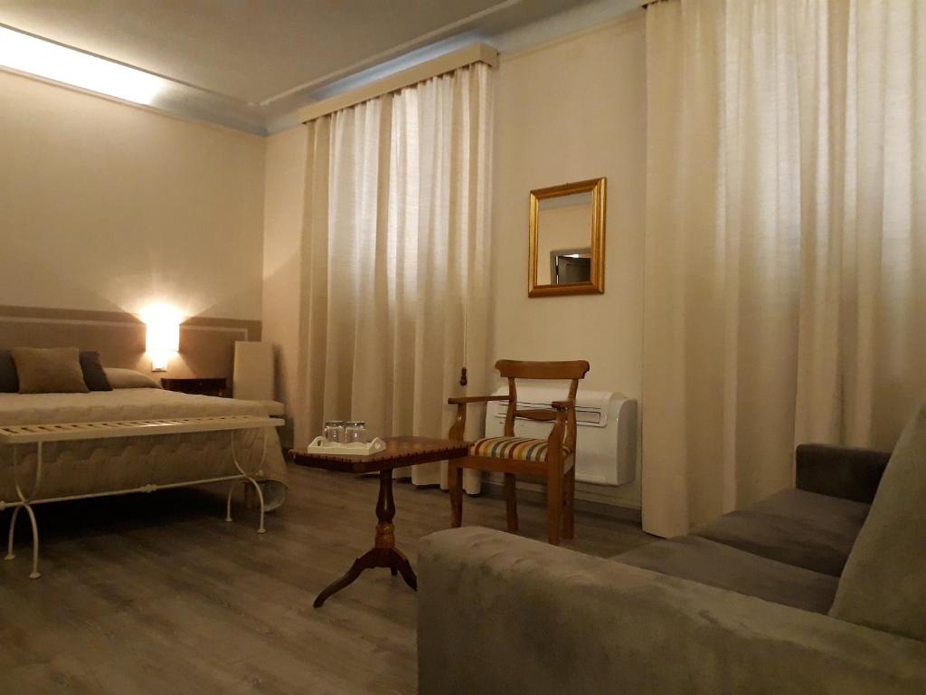 uma sala de estar com uma cama e um sofá em Le Camere di Caterina em Lucca