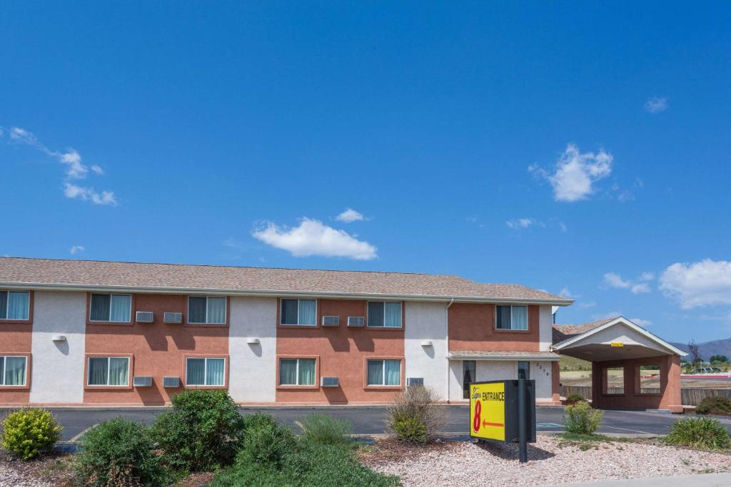 un edificio con una señal delante de él en Super 8 by Wyndham Colorado Springs/Chestnut Street, en Colorado Springs