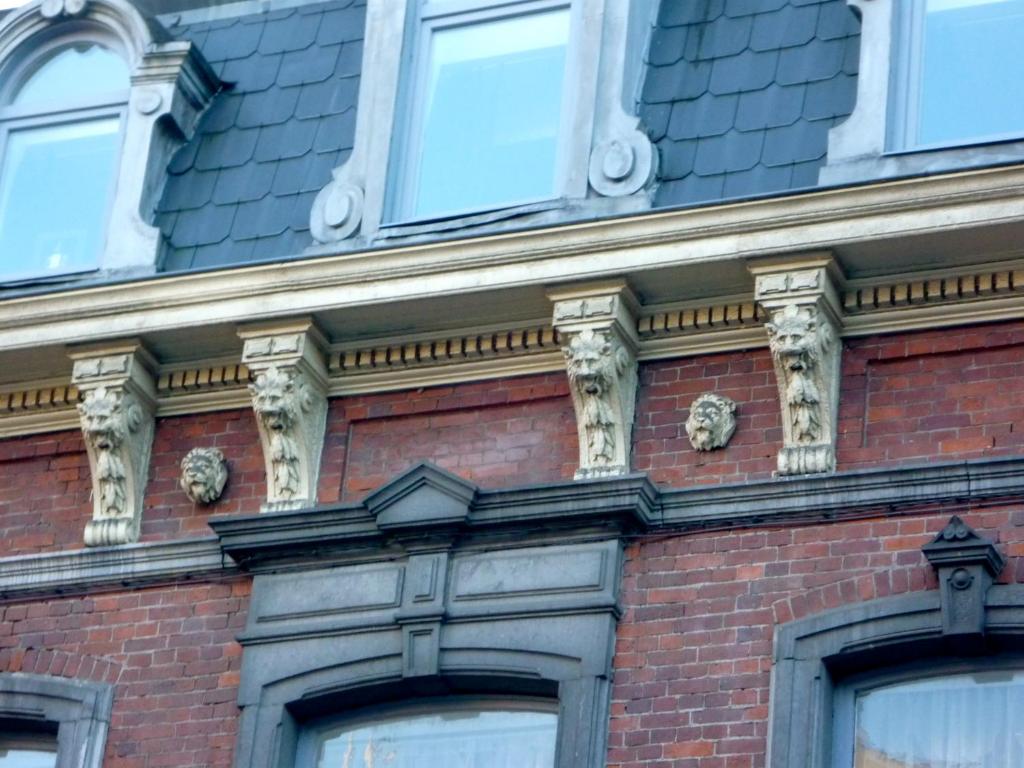 un edificio di mattoni con gargoyle sopra di Les Gîtes Du Pays De Charleroi a Charleroi