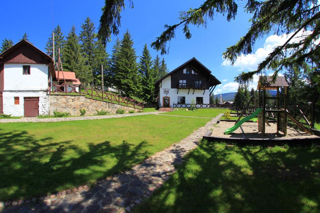 einen Park mit einem Haus und einem Spielplatz in der Unterkunft Pensiunea Rafael in Păltiniş