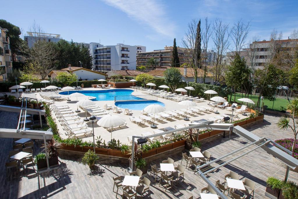 une piscine extérieure avec des chaises blanches et des parasols dans l'établissement Aparthotel Cye Holiday Centre, à Salou