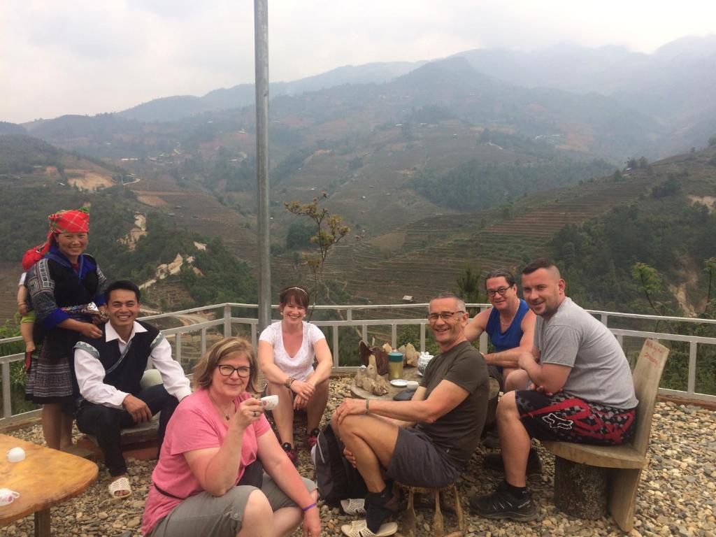 un gruppo di persone seduti su panchine in montagna di Hello Mu Cang Chai Homestay & Tours a Mù Cang Chải