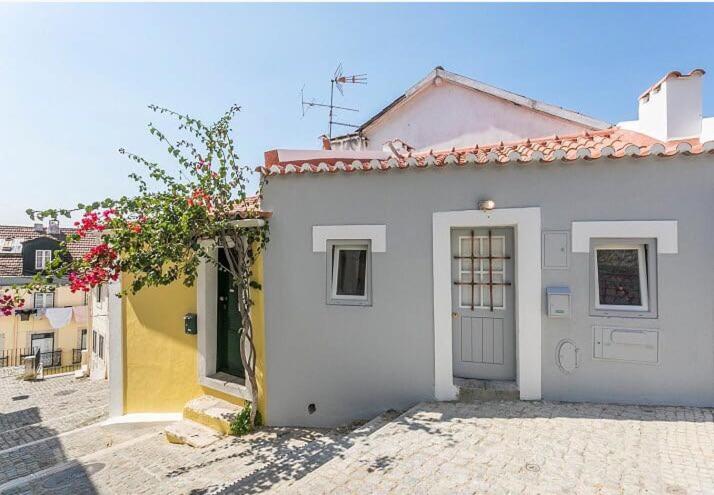 una casa bianca con una porta e dei fiori di Unique Studio House | City Centre a Lisbona