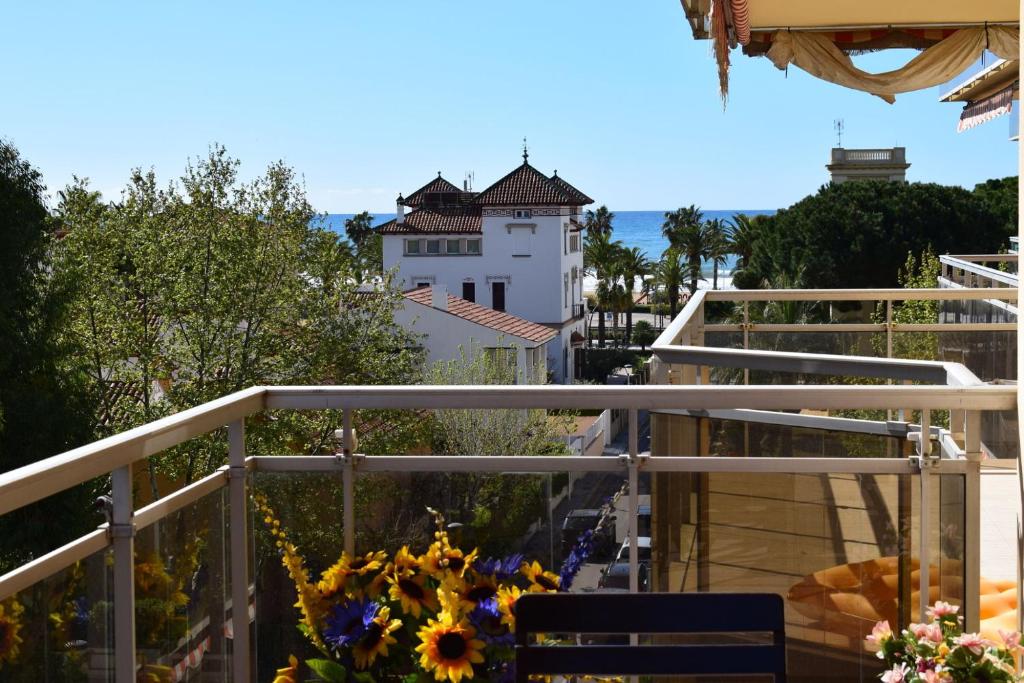 een balkon met bloemen en een gebouw op de achtergrond bij DIFFERENTFLATS Palafox in Salou