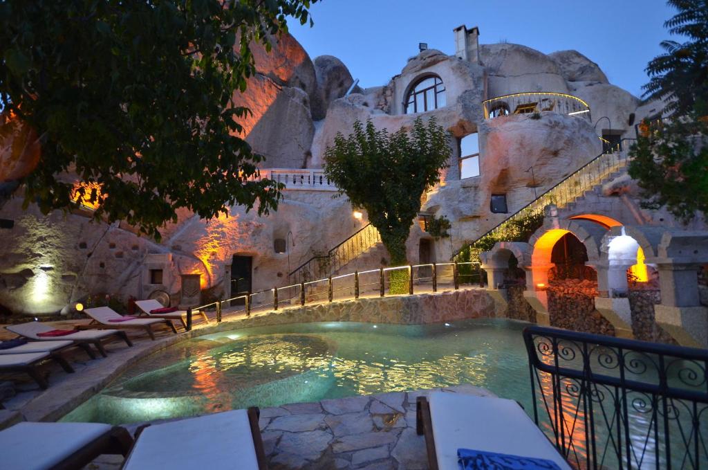 a swimming pool in front of a building at Cappadocia Gamirasu Cave Hotel in Urgup