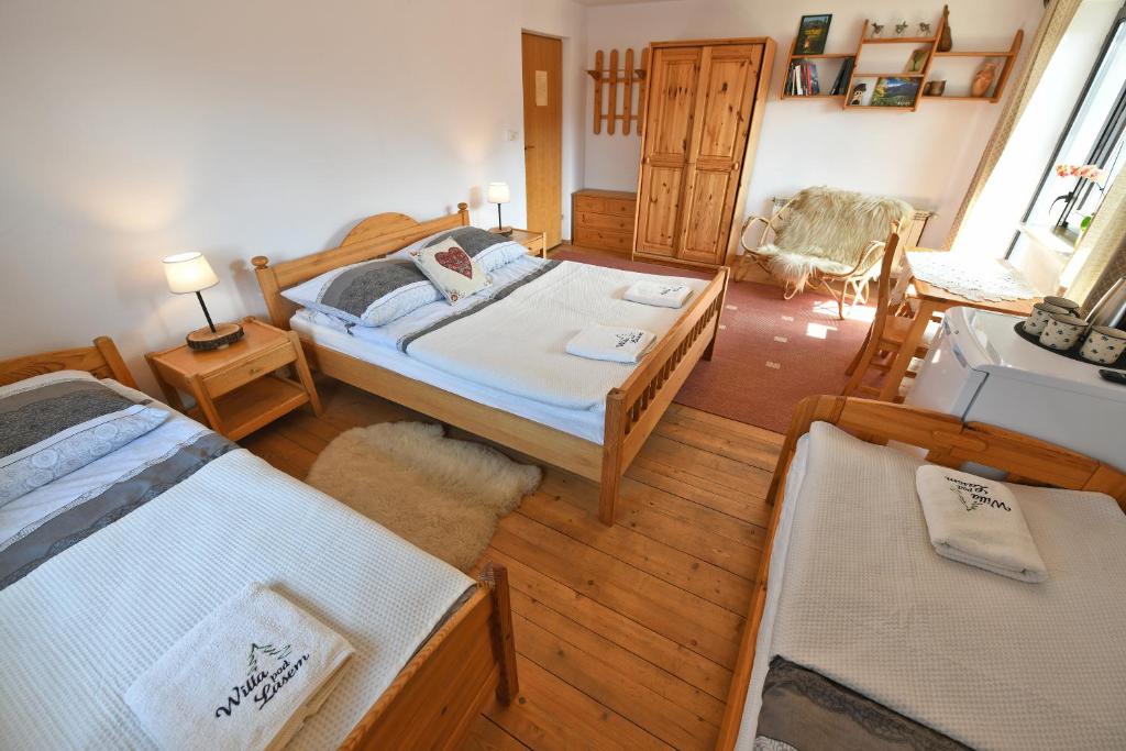 a bedroom with two beds and a table and chairs at Willa Pod Lasem in Kościelisko