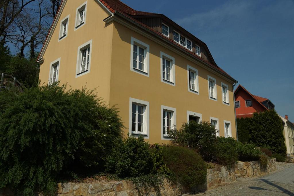 un edificio amarillo con ventanas blancas en una calle en Ferienwohnung am Spreeradweg in Bautzen, en Bautzen