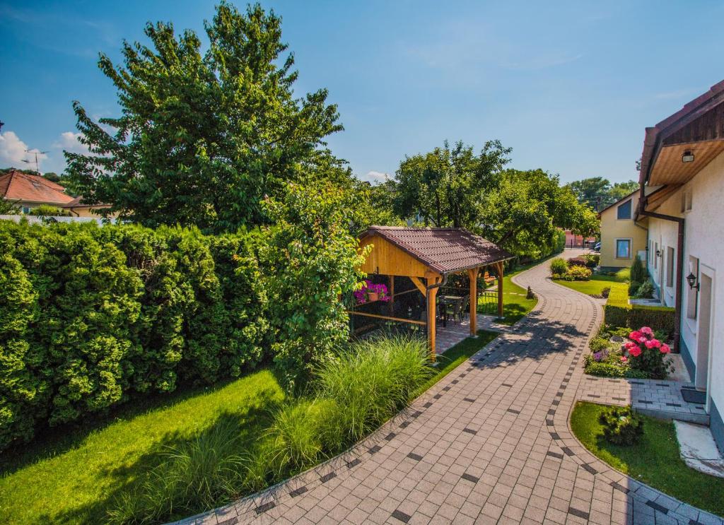 een tuin met een prieel naast een gebouw bij Pension Danninger in Piešťany