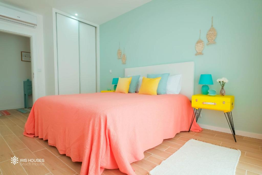 - une chambre avec un lit et une couverture orange dans l'établissement Iris Apartment, à Nazaré