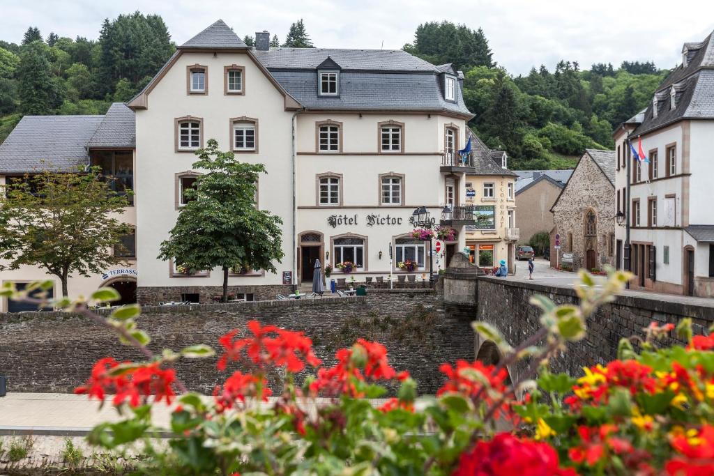 una ciudad con edificios y flores en primer plano en Hôtel - Restaurant " Victor Hugo", en Vianden