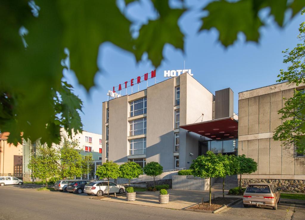 un hotel con auto parcheggiate di fronte di Hotel Laterum a Pécs