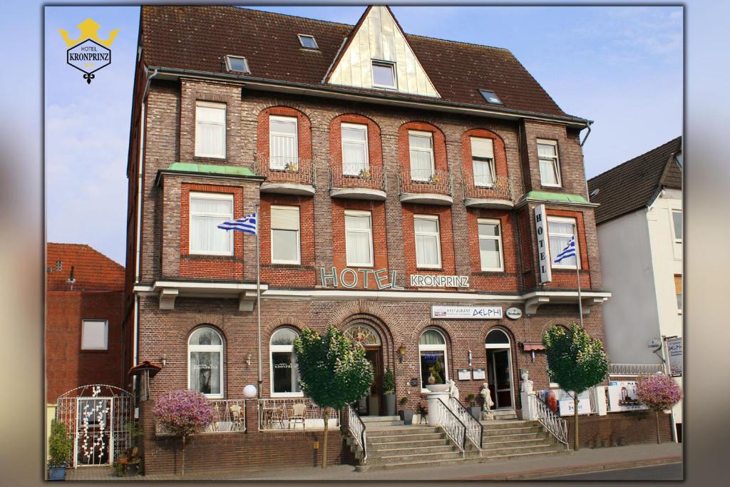 un grand bâtiment en briques rouges avec un hôtel dans l'établissement Hotel Kronprinz, à Emden