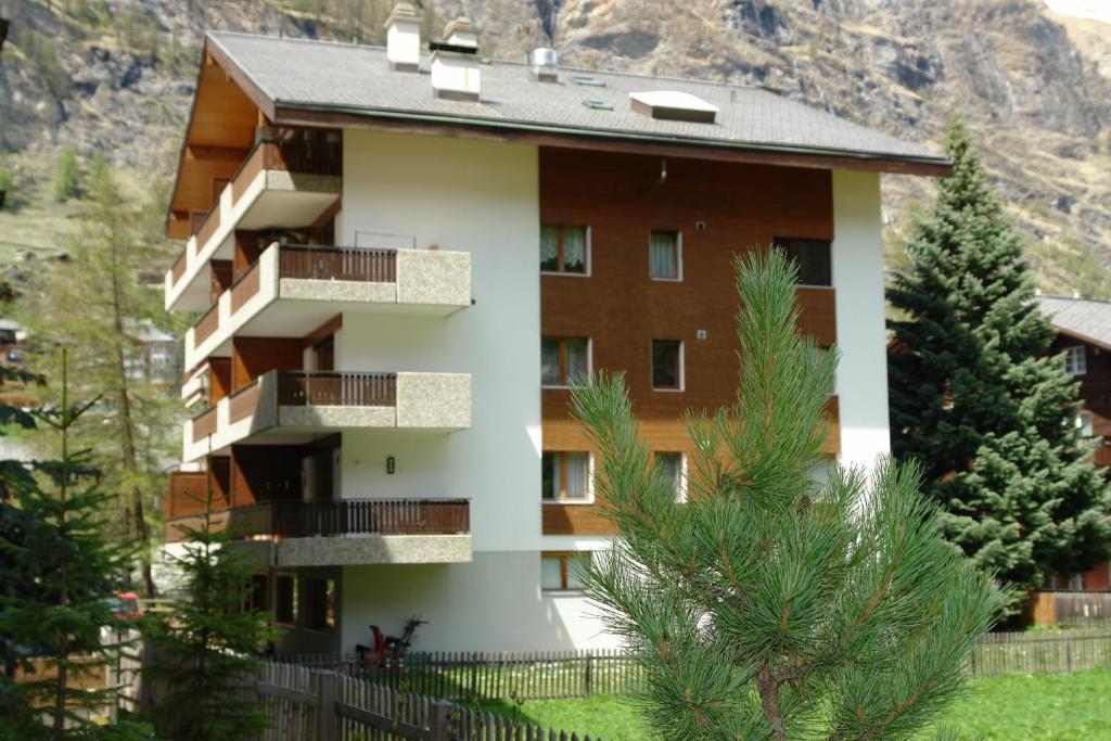 um edifício com varandas e árvores em frente a uma montanha em Myzermatt Monazit em Zermatt