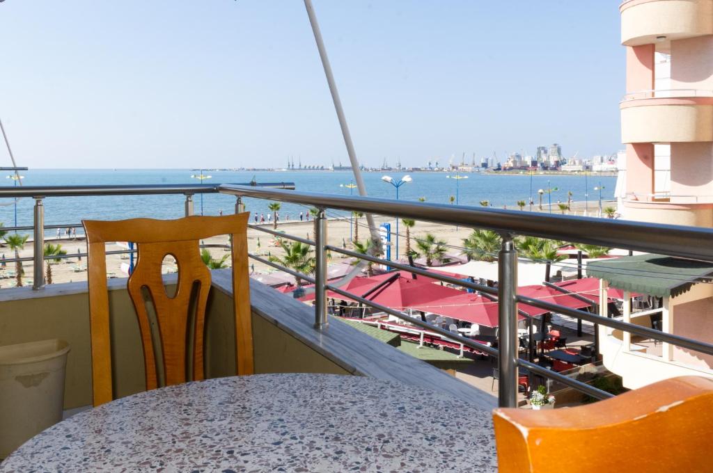 a table and chairs on a balcony with a view of the beach at Comfortable apartment next to the beach in Durrës