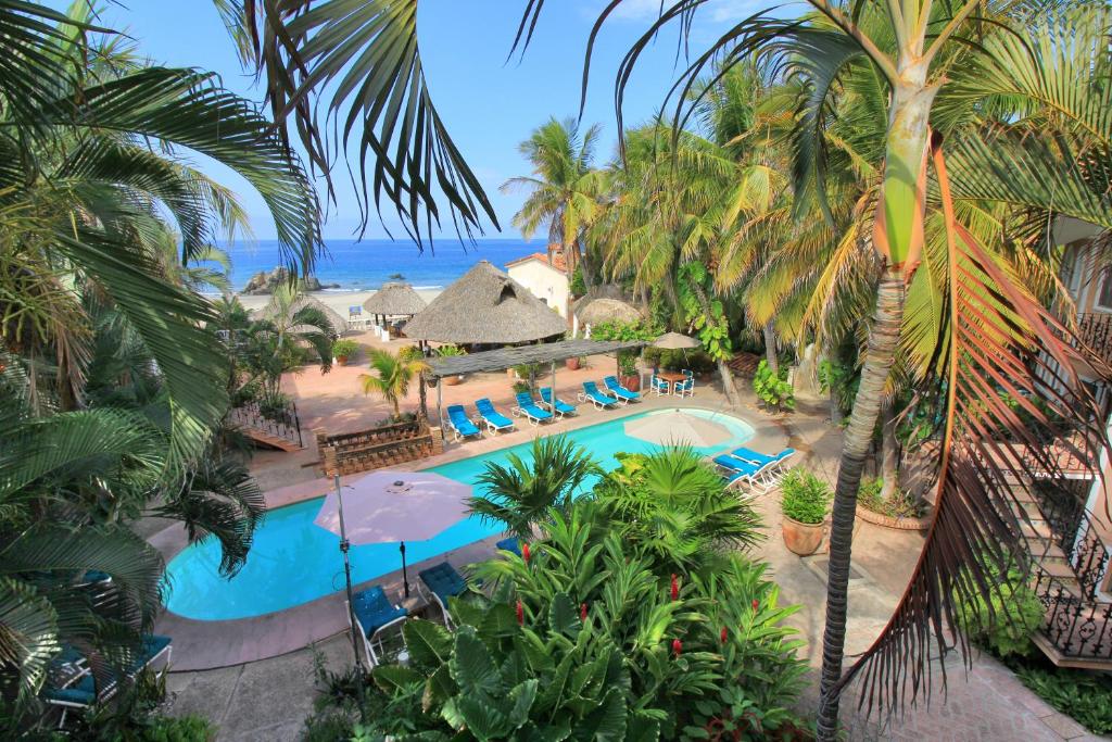 an aerial view of a resort swimming pool with palm trees at Hotel Santa Fe in Puerto Escondido