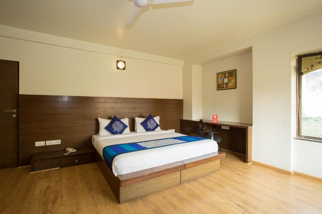 1 dormitorio con 1 cama grande con almohadas azules en Corporate Stay, en Pune