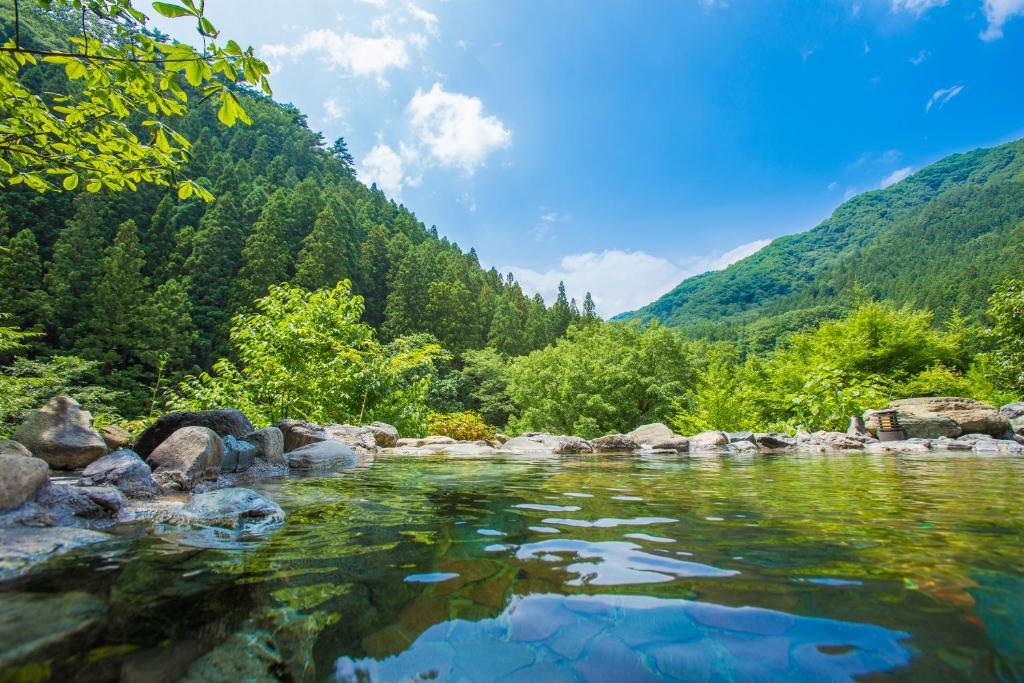 um rio nas montanhas com pedras na água em Minakamisansou em Minakami