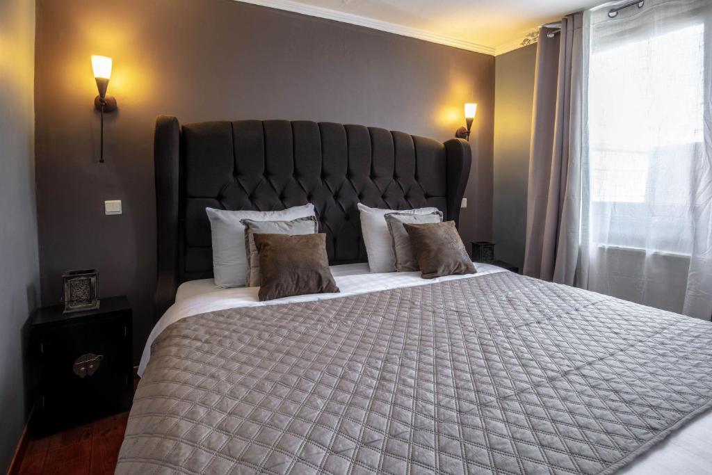 a bedroom with a large bed with a large headboard at Park Hotel Airport in Charleroi