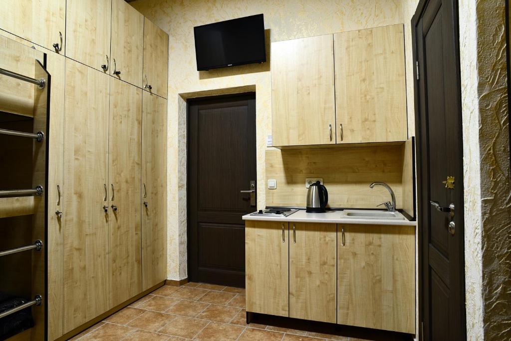 una cucina con armadi in legno, lavandino e porta di Logovo Hostel a Odessa