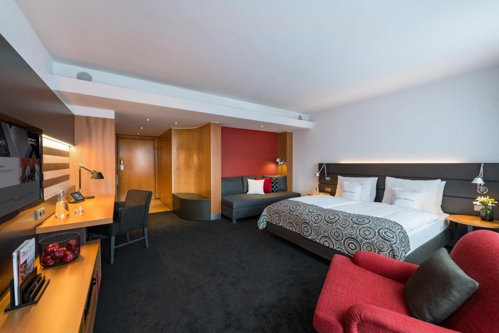 um quarto de hotel com uma cama grande e um sofá em THE MADISON Hotel Hamburg em Hamburgo