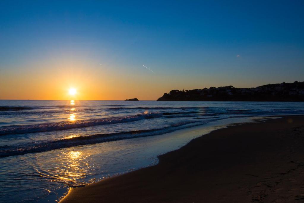 a sunset on a beach with the ocean at Serapo Bed and Breakfast in Gaeta