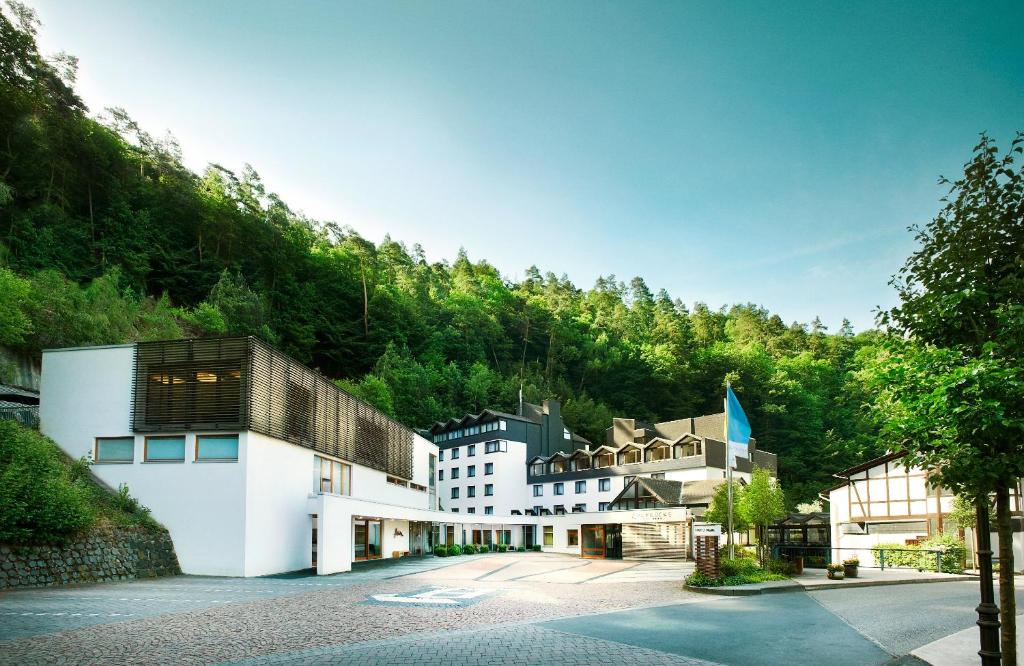 un groupe de bâtiments devant une montagne dans l'établissement Hotel Zugbrücke Grenzau GmbH, à Höhr-Grenzhausen