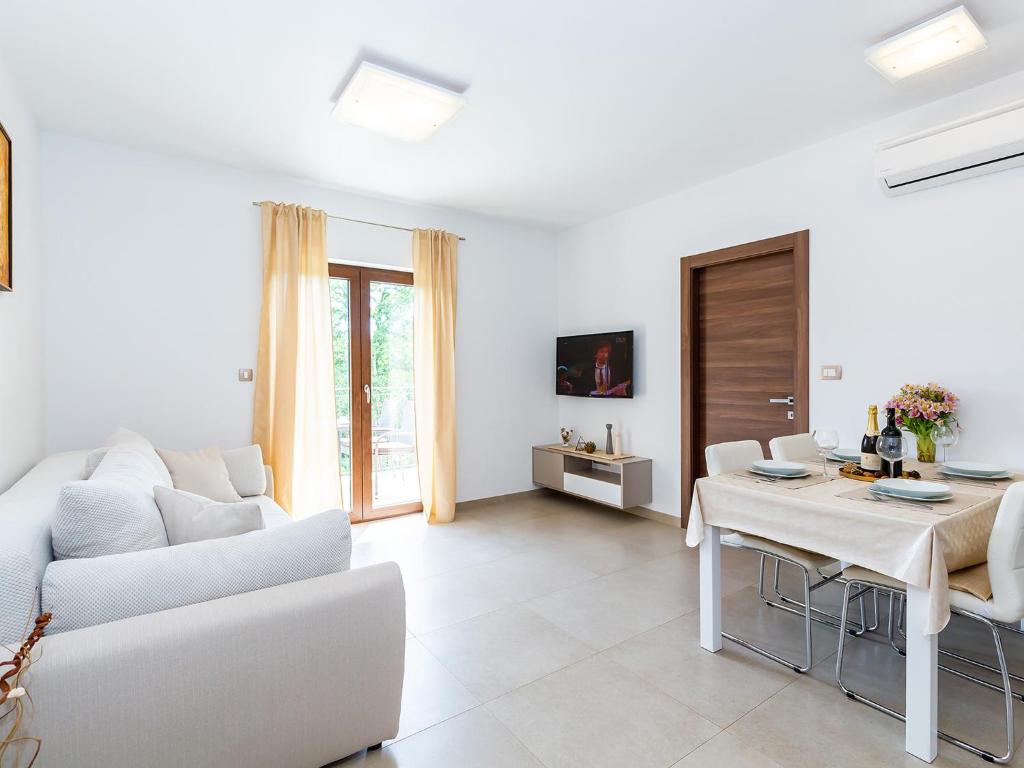 - un salon blanc avec un canapé blanc et une table dans l'établissement Apartments Gioia, à Poreč