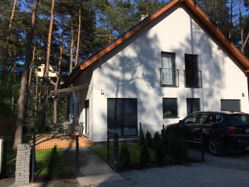 a car parked in front of a white house at The Place by Baltic sea in Łukęcin