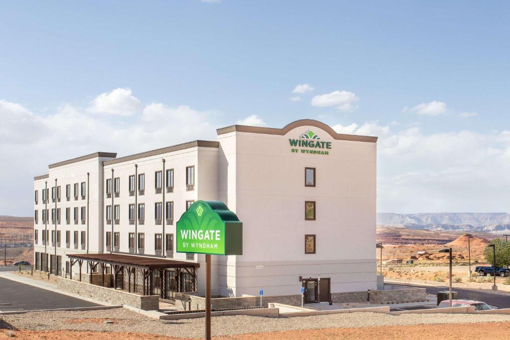 un bâtiment blanc avec un panneau devant lui dans l'établissement Wingate by Wyndham Page Lake Powell, à Page