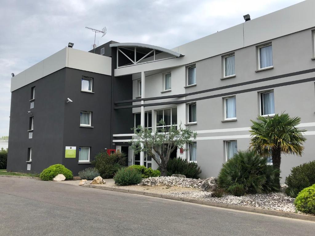 a white building with a lot of windows at B&B HOTEL Montauban in Montauban