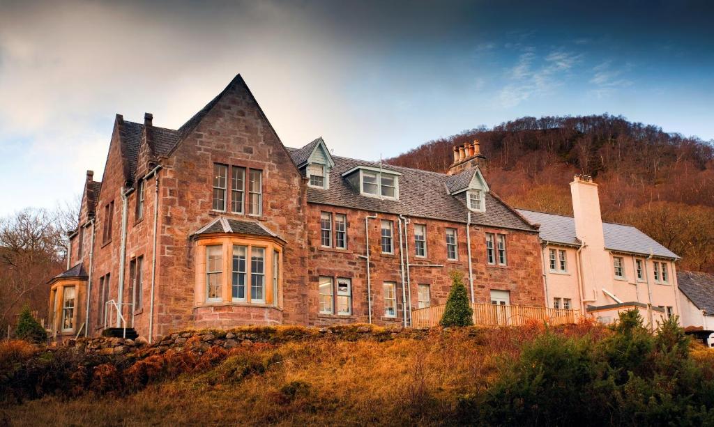 un grande edificio in mattoni in cima a una collina di Loch Maree Hotel a Talladale