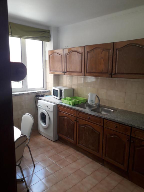 a kitchen with a sink and a washing machine at Apartamento 300 metros do SANTUÁRIO DE FÁTIMA T4 in Fátima