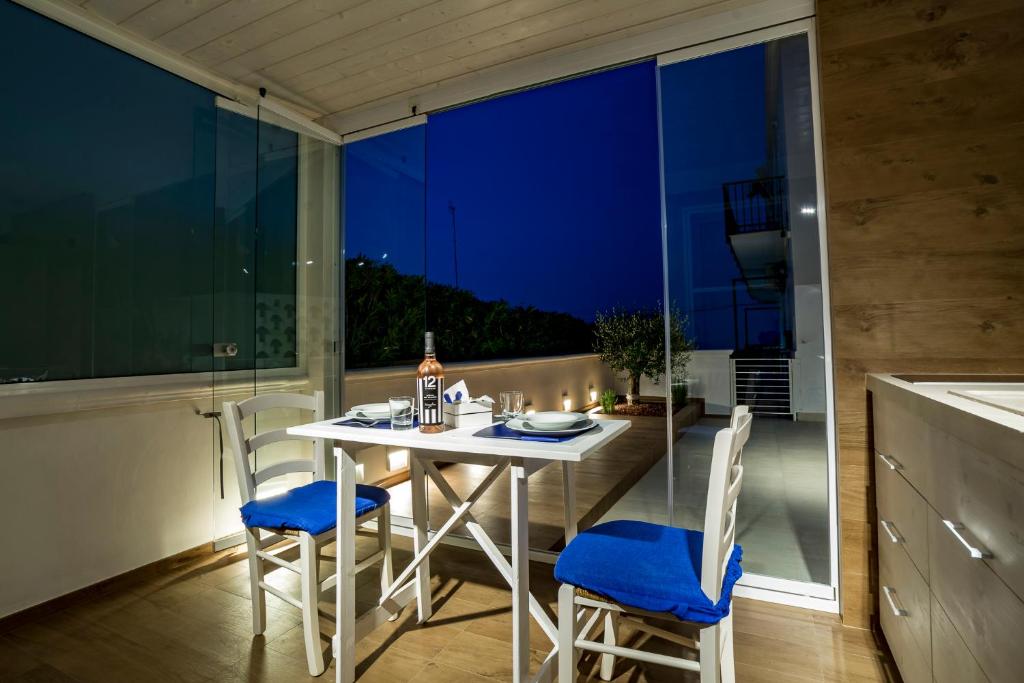 een witte tafel en stoelen in een kamer met een raam bij Casa Damare Capitolo in Monopoli