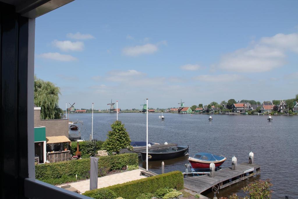 een uitzicht op een rivier met boten in het water bij Boutique Hotel Zaan in Zaandijk