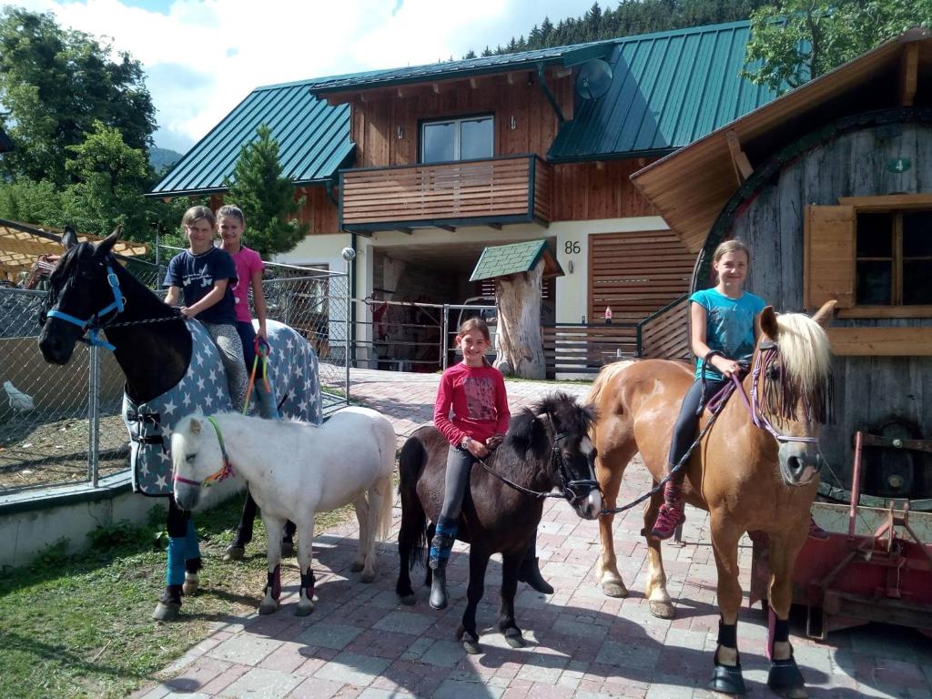 un groupe d'enfants à cheval devant une maison dans l'établissement Appartment Iris, à Aich