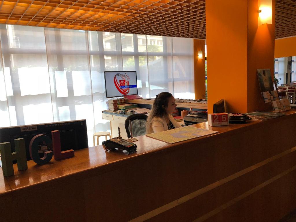 a woman sitting at a desk in an office at Hotel Ceresio in Lugano