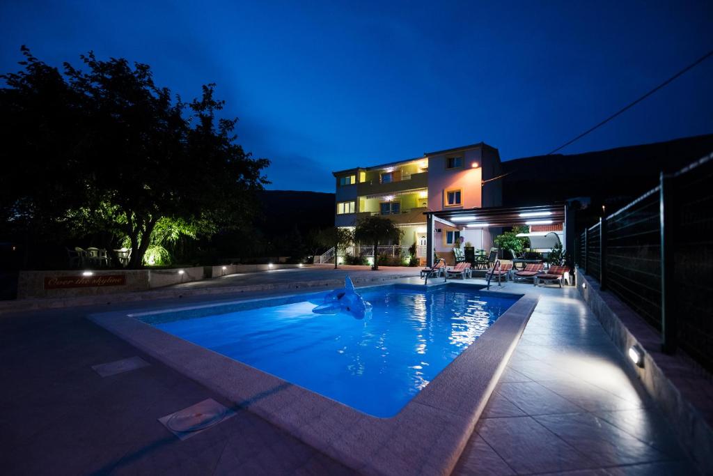 - une piscine en face d'un bâtiment la nuit dans l'établissement Over the skyline, à Podstrana