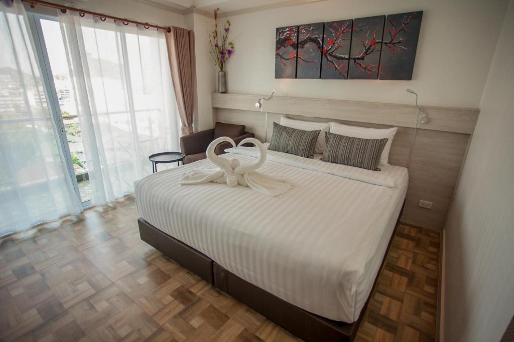 una camera da letto con un letto decorato con cigno di City View Residence a Si Racha