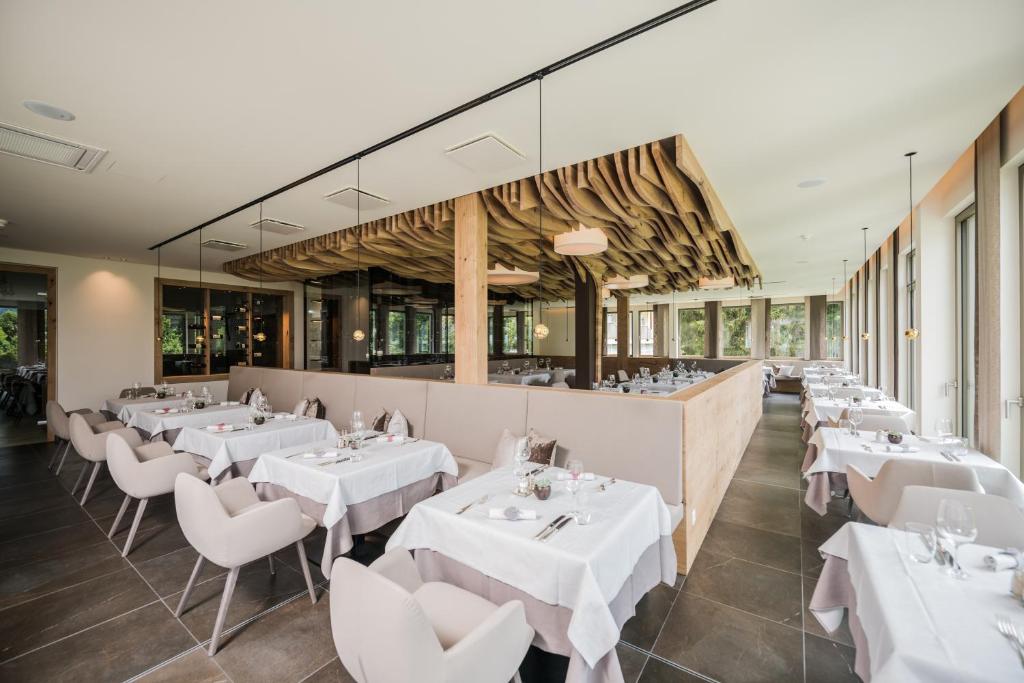 een eetkamer met witte tafels en stoelen bij Park Hotel Bellevue in Dobbiaco