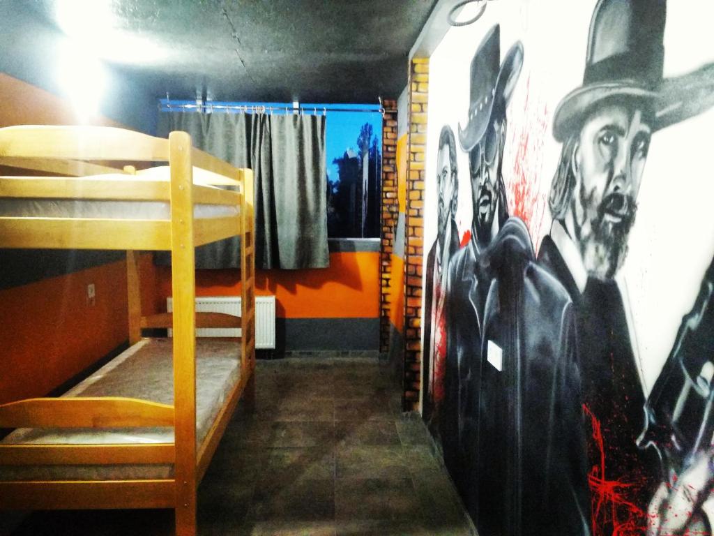 Zimmer mit einem Bett und einer Wand mit einem Gemälde in der Unterkunft Graffiti Mega City in Kiew